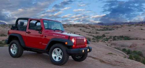 Red Jeep on red slickrock in Moab, Utah