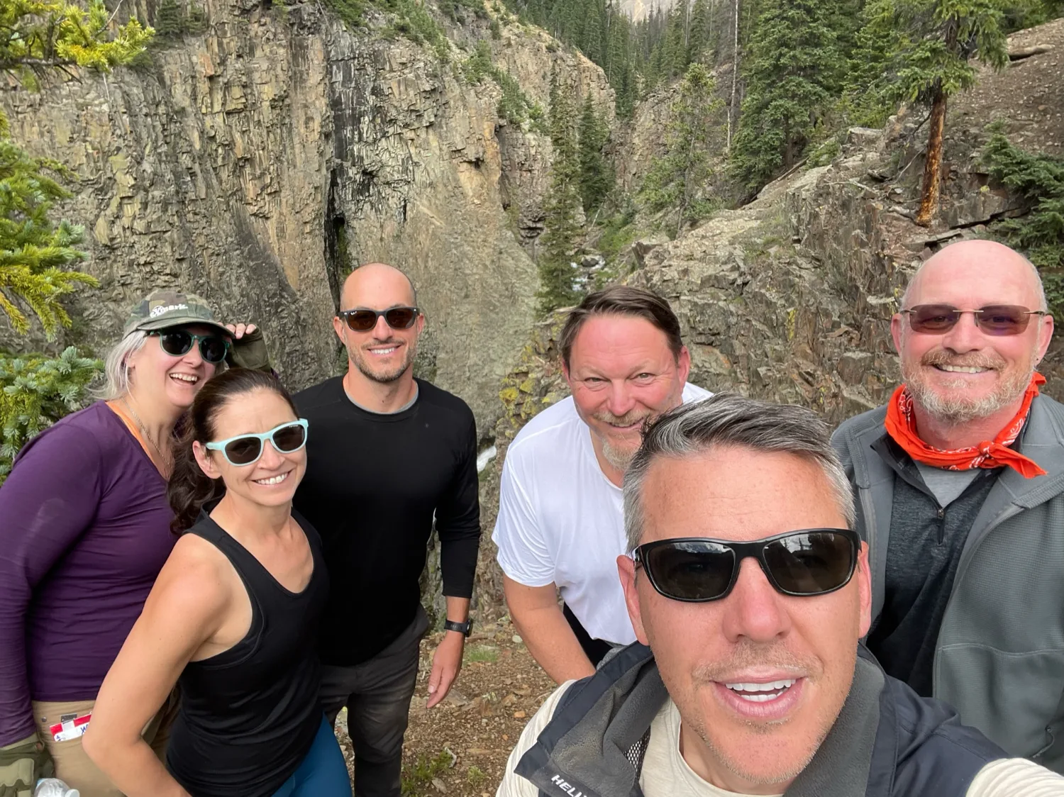 An executive team gathered for a photo in a Colorado canyon