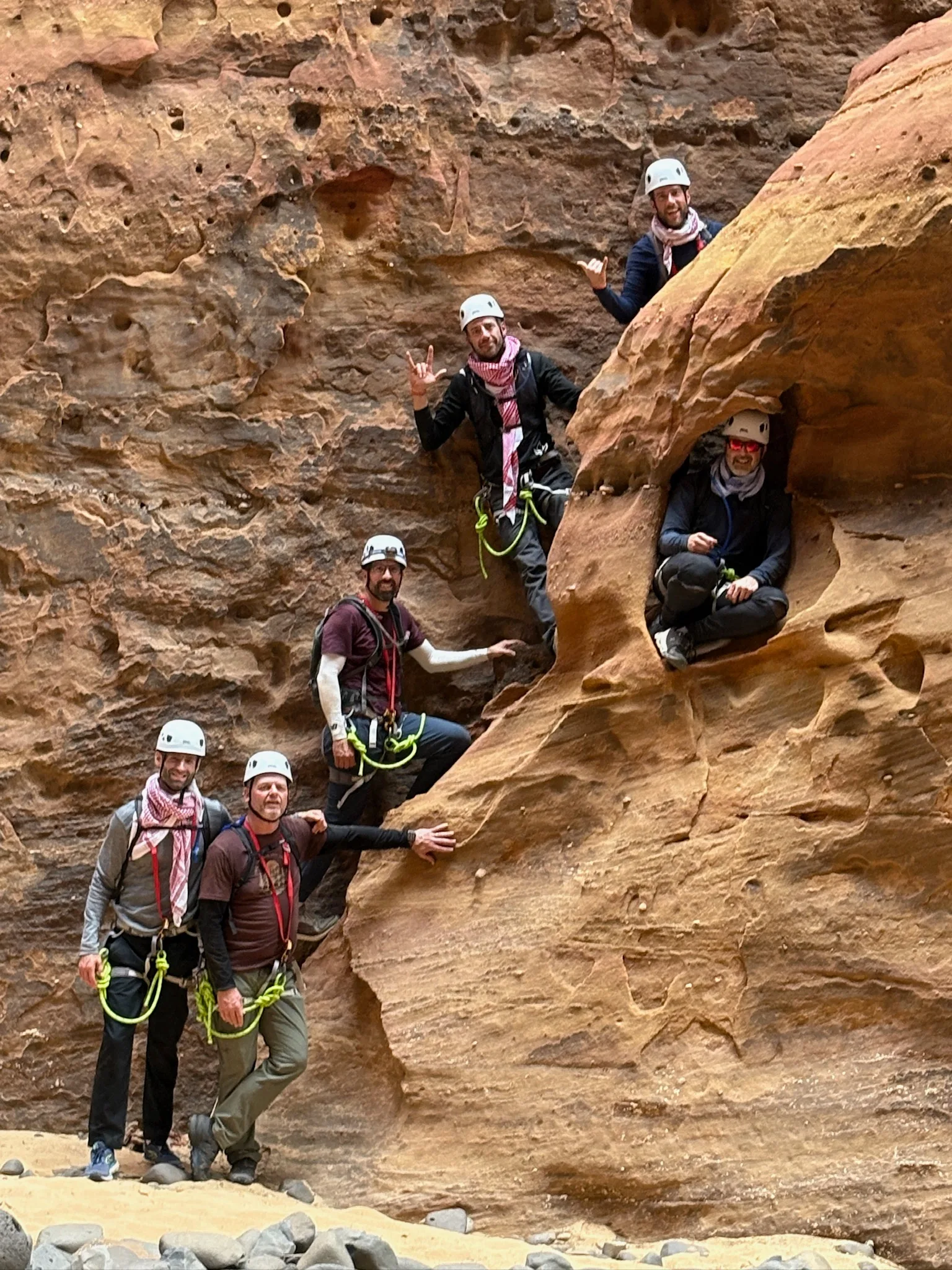 Executive team climbing a sandstone face together in the wilderness