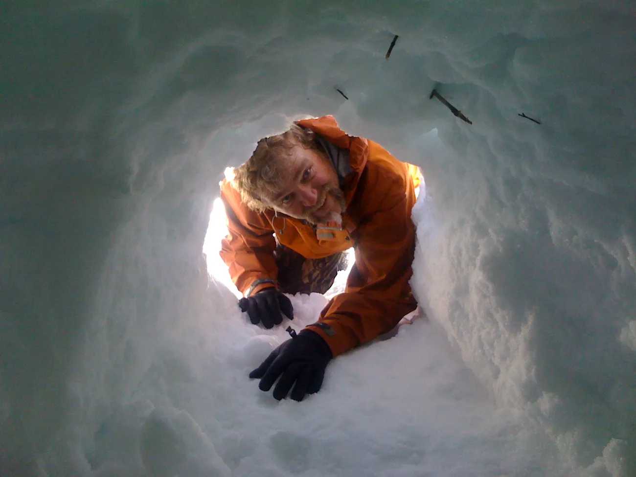An executive inside a snow shelter on a winter survival retreat